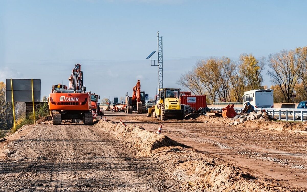 Eine Baustelle auf der Autobahn mit Stau und Bagger Eine Baustelle auf der Autobahn mit Stau und Bagger